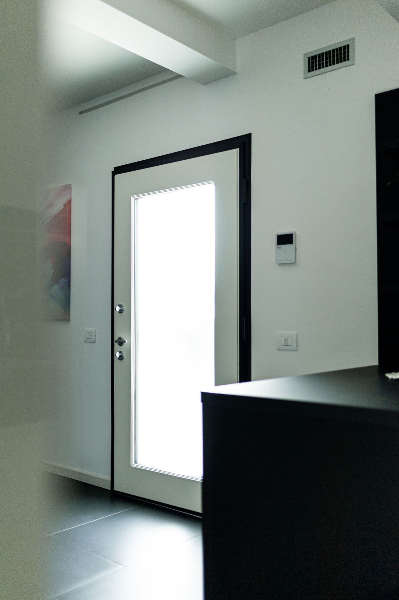 Ingresso interno luminoso con porta vetrata installata da Quadra Serramenti
