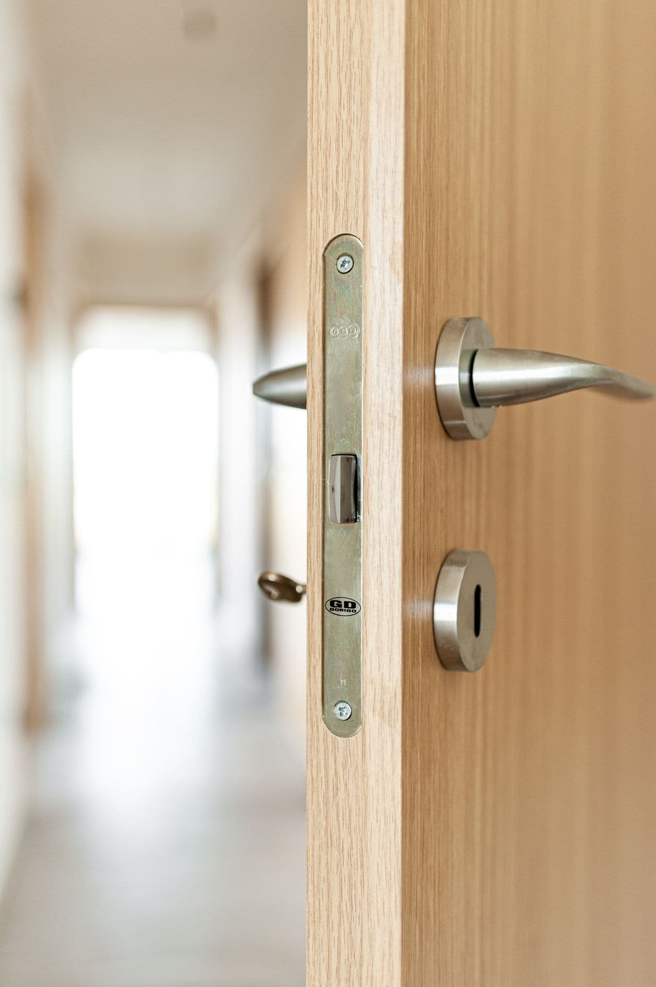 Porta interna scorrevole in legno chiaro aperta su un bagno moderno